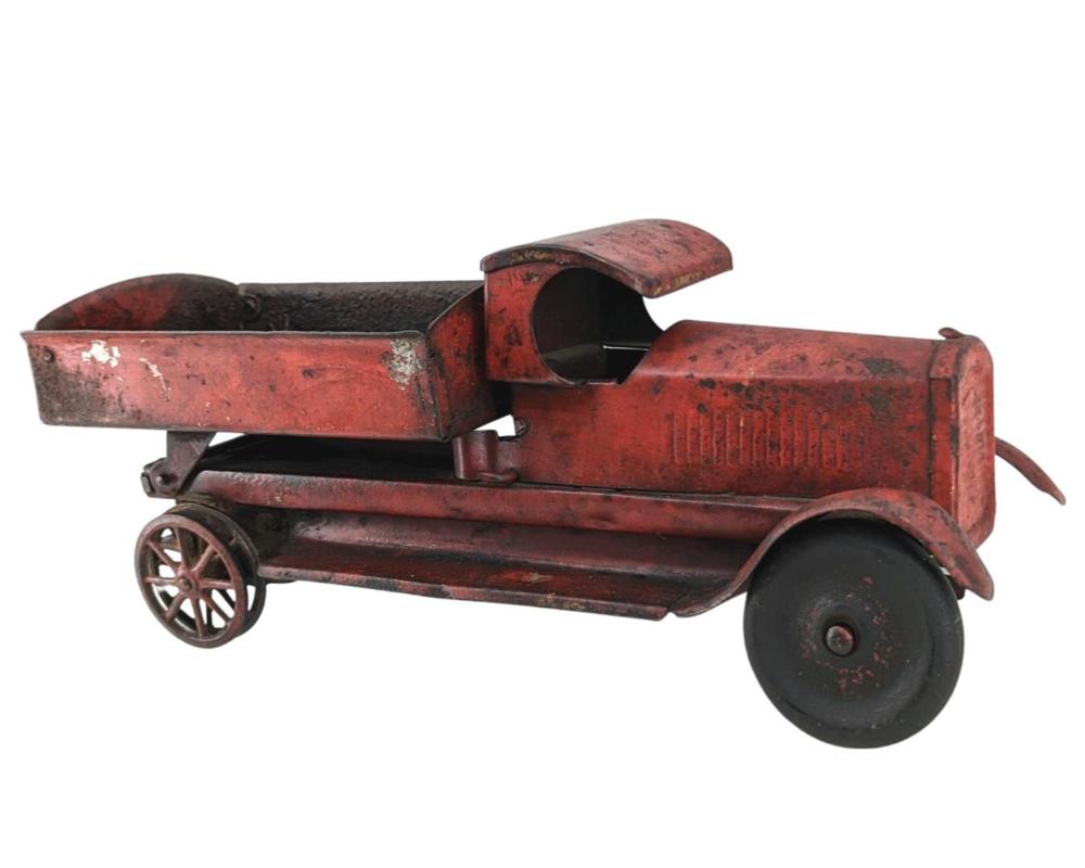 Red metal antique toy truck with black rubber wheels, shown in profile on a white background.