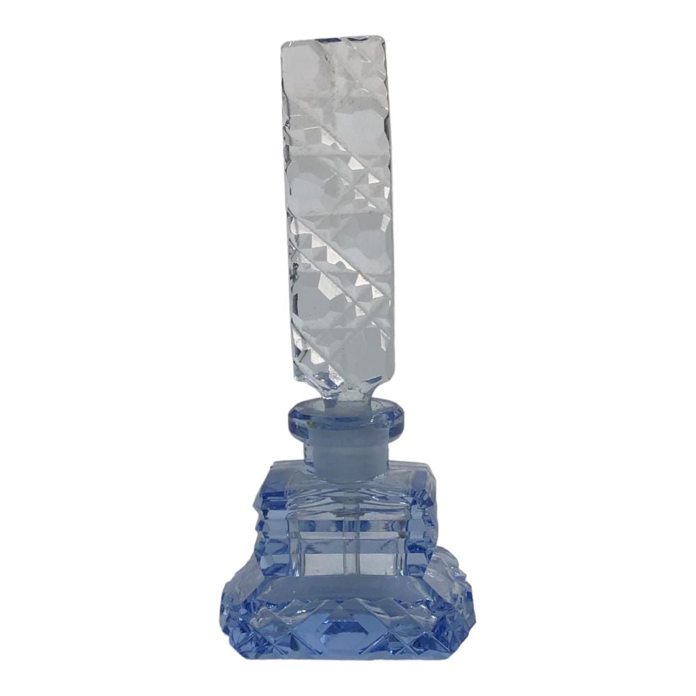 Blue and clear glass perfume bottle with a faceted body and geometric cut pattern, shown upright against a white background.