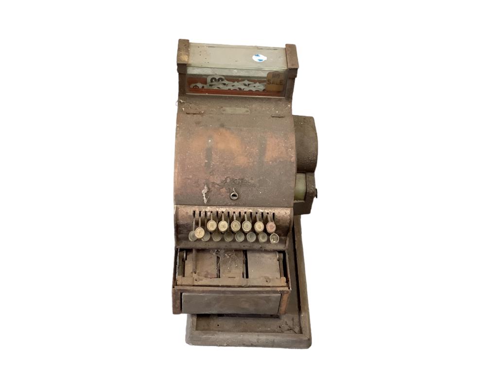 Antique-style metal cash register with a slanted face, row of coin dials, and open cash drawer, shown front view.