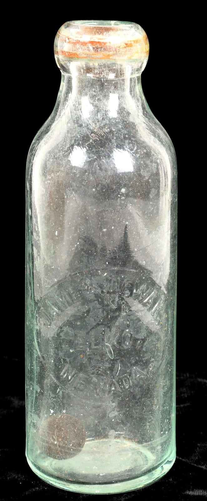 Clear glass soda bottle with a rounded neck and narrow shoulders, shown upright against a black background.