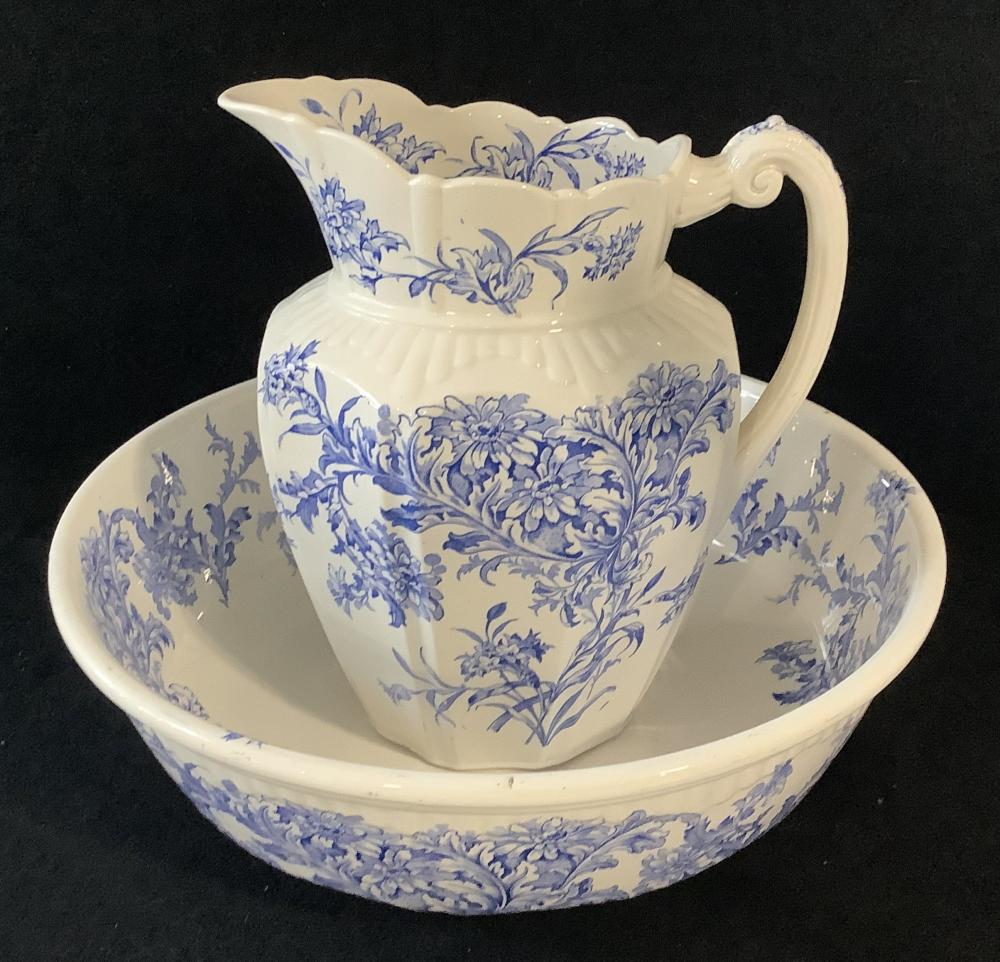 White ceramic wash basin with blue floral transfer-print pattern and a matching blue-and-white pitcher on top