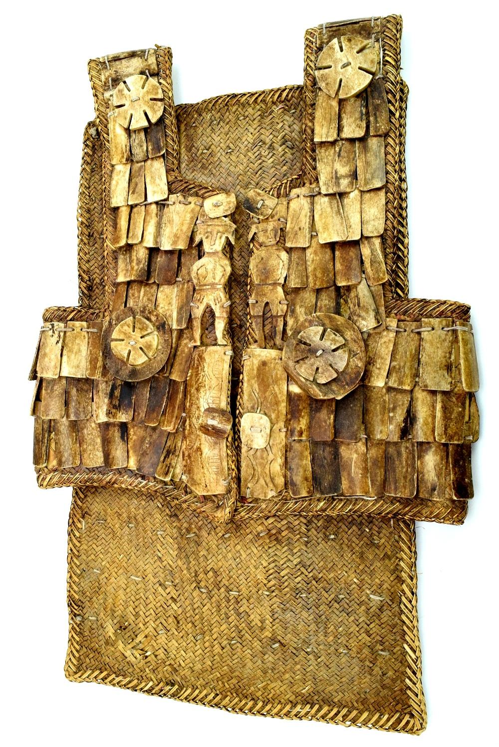 Woven rattan torso armor vest with overlapping metal plates and round sunburst ornaments.