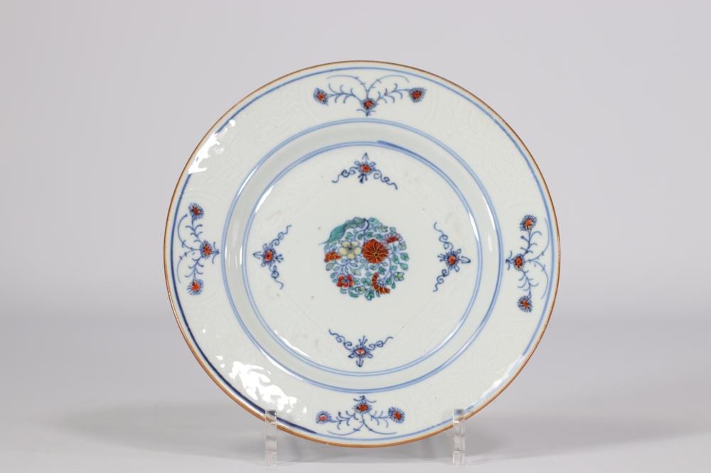 Chinese porcelain plate with blue-and-red floral decoration and a gold rim, shown centered on a stand.