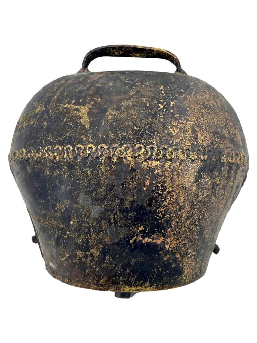 Bronze cow bell with a dark patina and gold-toned surface speckling, with a metal handle loop on top.