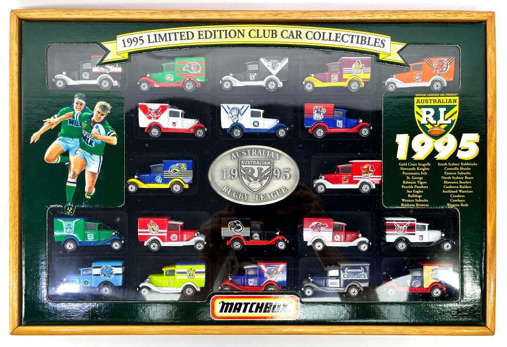Matchbox display case showing multiple small diecast cars with rugby league logos and a 1995 limited edition banner.