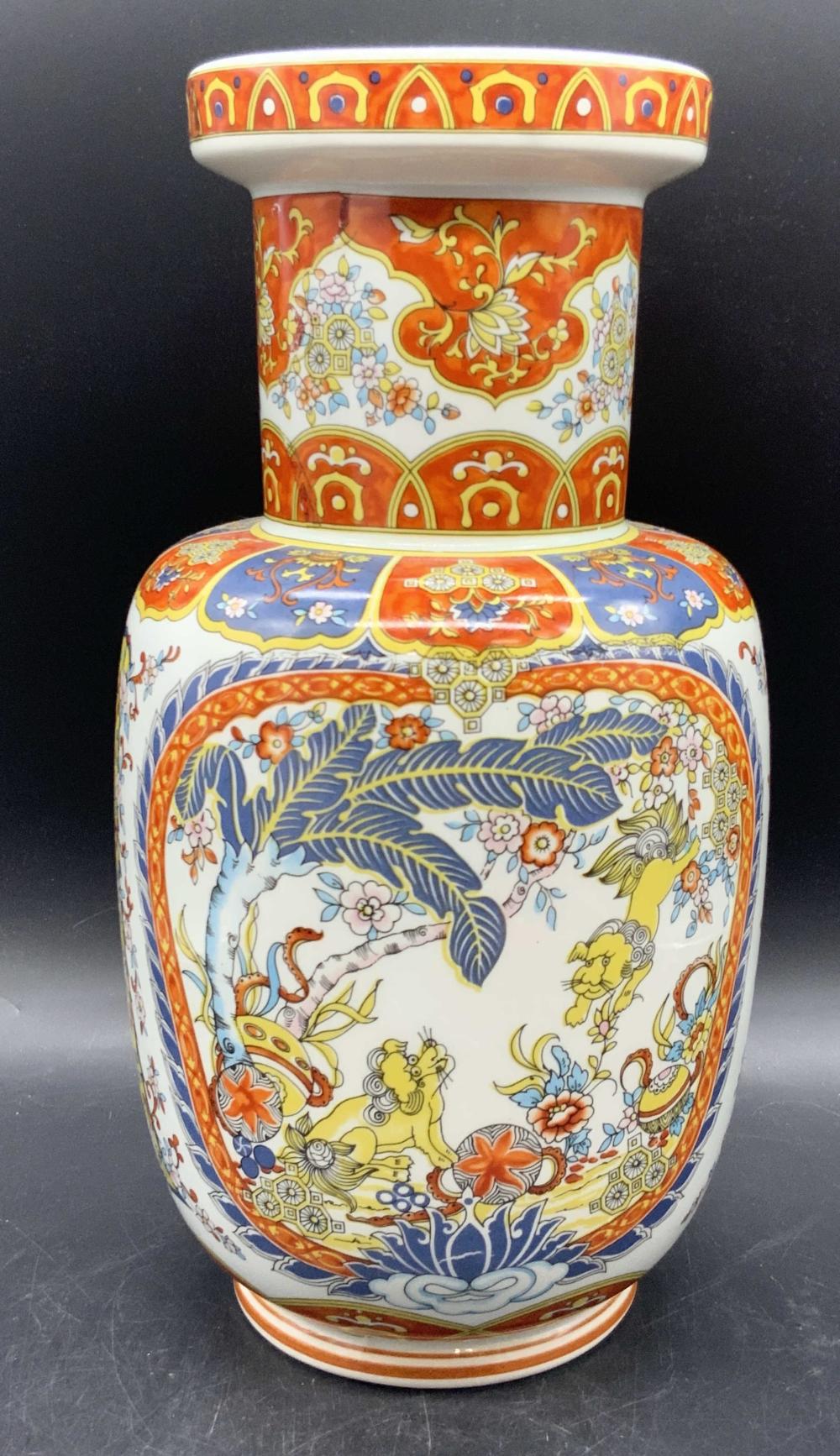 Colorful ceramic vase with chinoiserie-style decoration and a red-and-white rim, shown against a dark background.