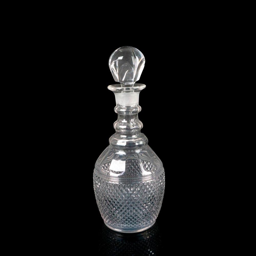 Clear pressed-glass decanter with a rounded stopper, shown against a black background.