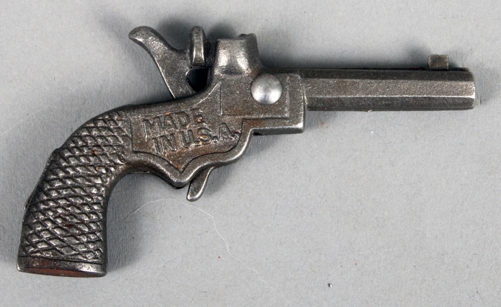 Metal cap gun shaped like a small pistol with a textured grip and a lever, shown on a light background.
