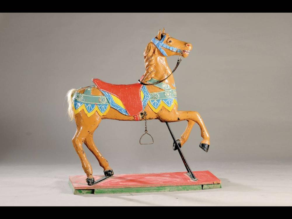 Painted carousel-style horse figure on a rectangular wooden base with colorful saddle decorations and a metal support.