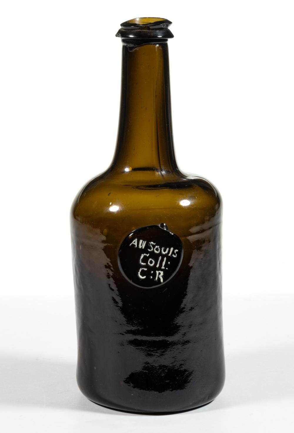 Amber and dark glass wine bottle with a black applied seal on the front that reads “All Souls Coll. C.R.”