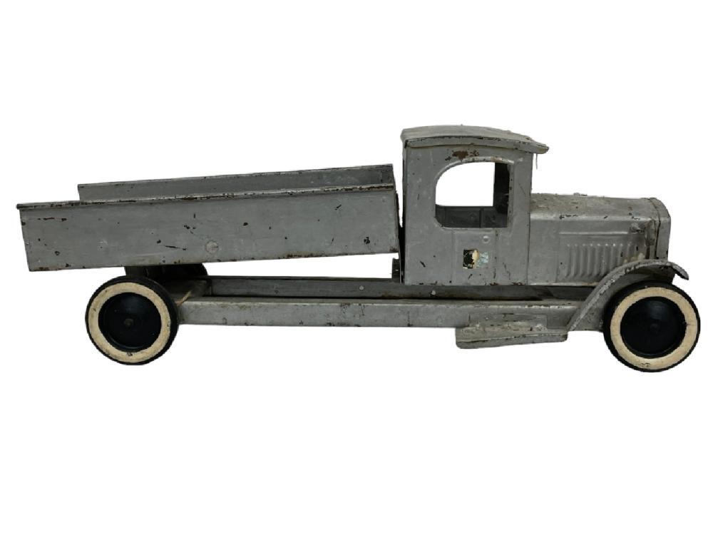 Gray antique-style metal toy truck with open flatbed and large black wheels with pale rims.