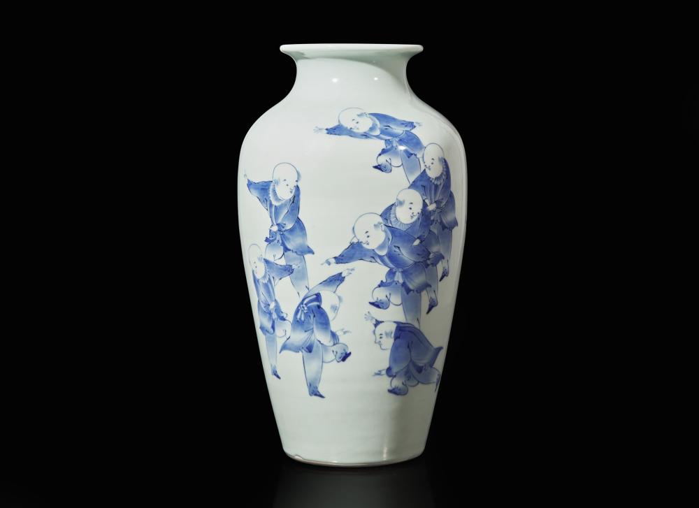 White porcelain vase with blue painted figures of children holding items, rounded body and flared rim against a dark background.