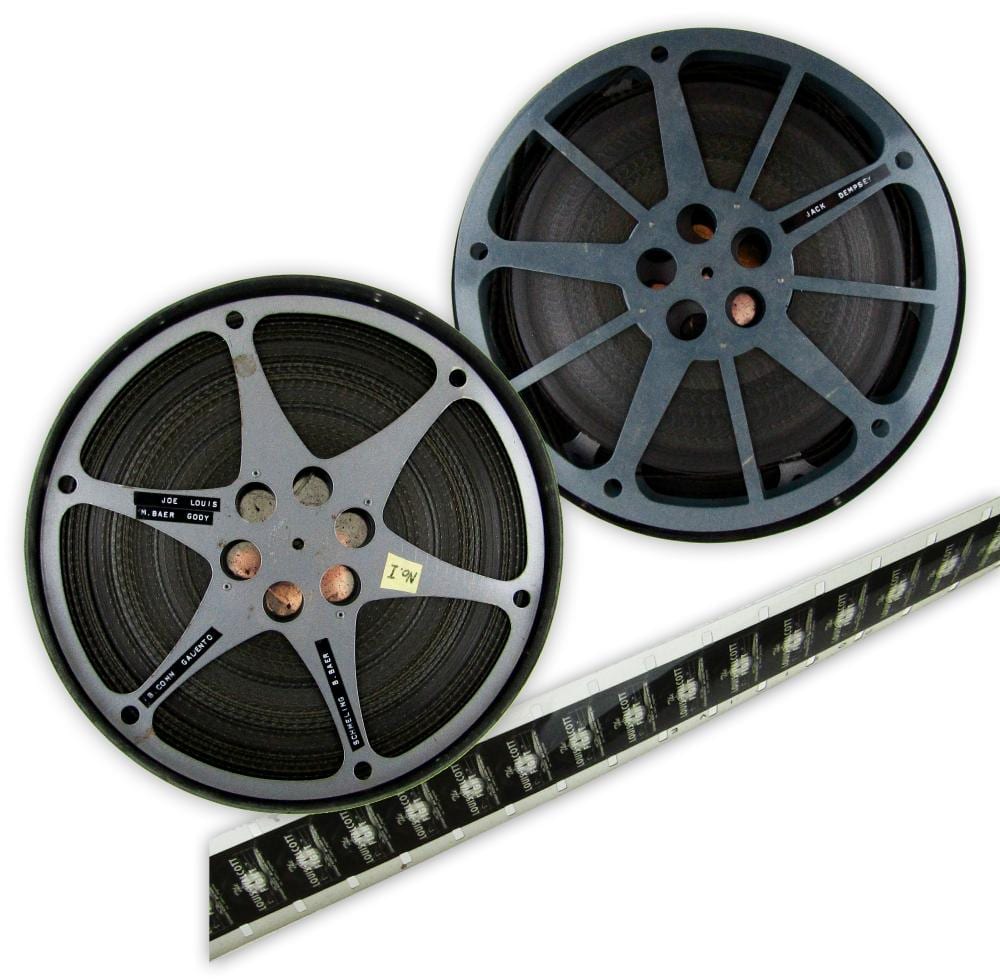 Two metal 16mm film reels with a film strip showing boxing names along the edge.