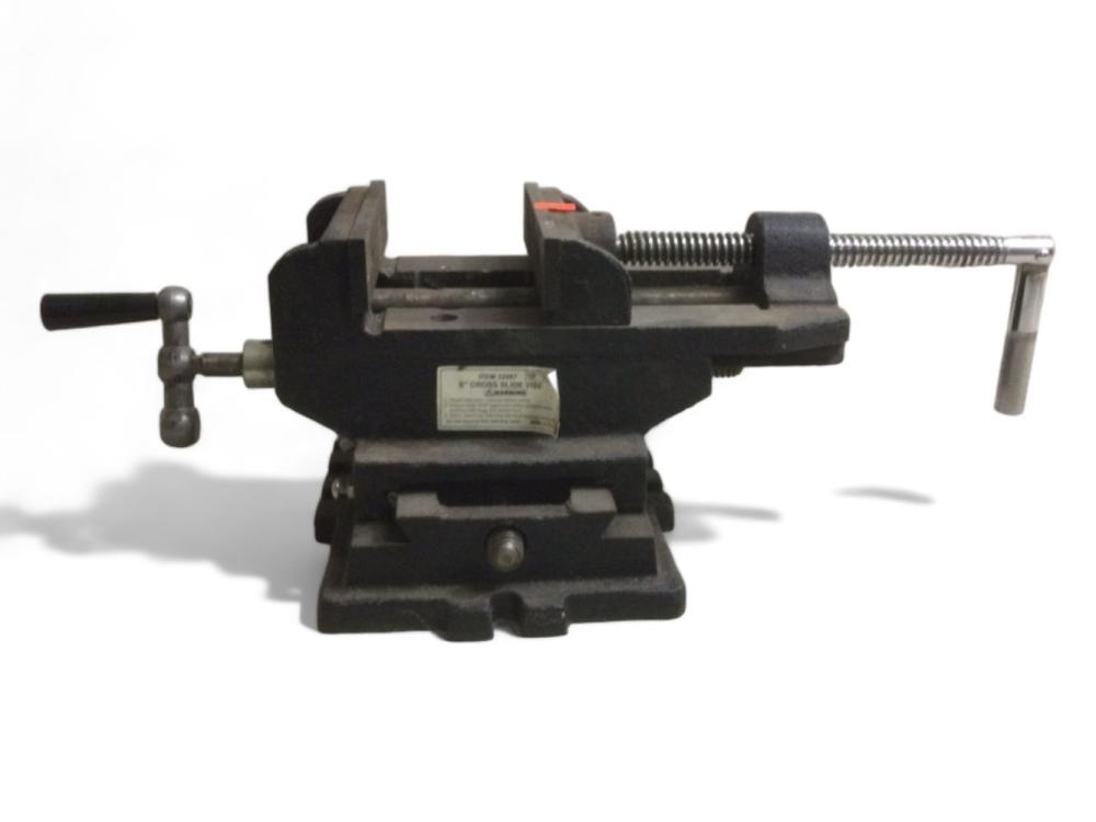 Black metal bench vise with a screw mechanism and handle, shown in a front view on a white background.