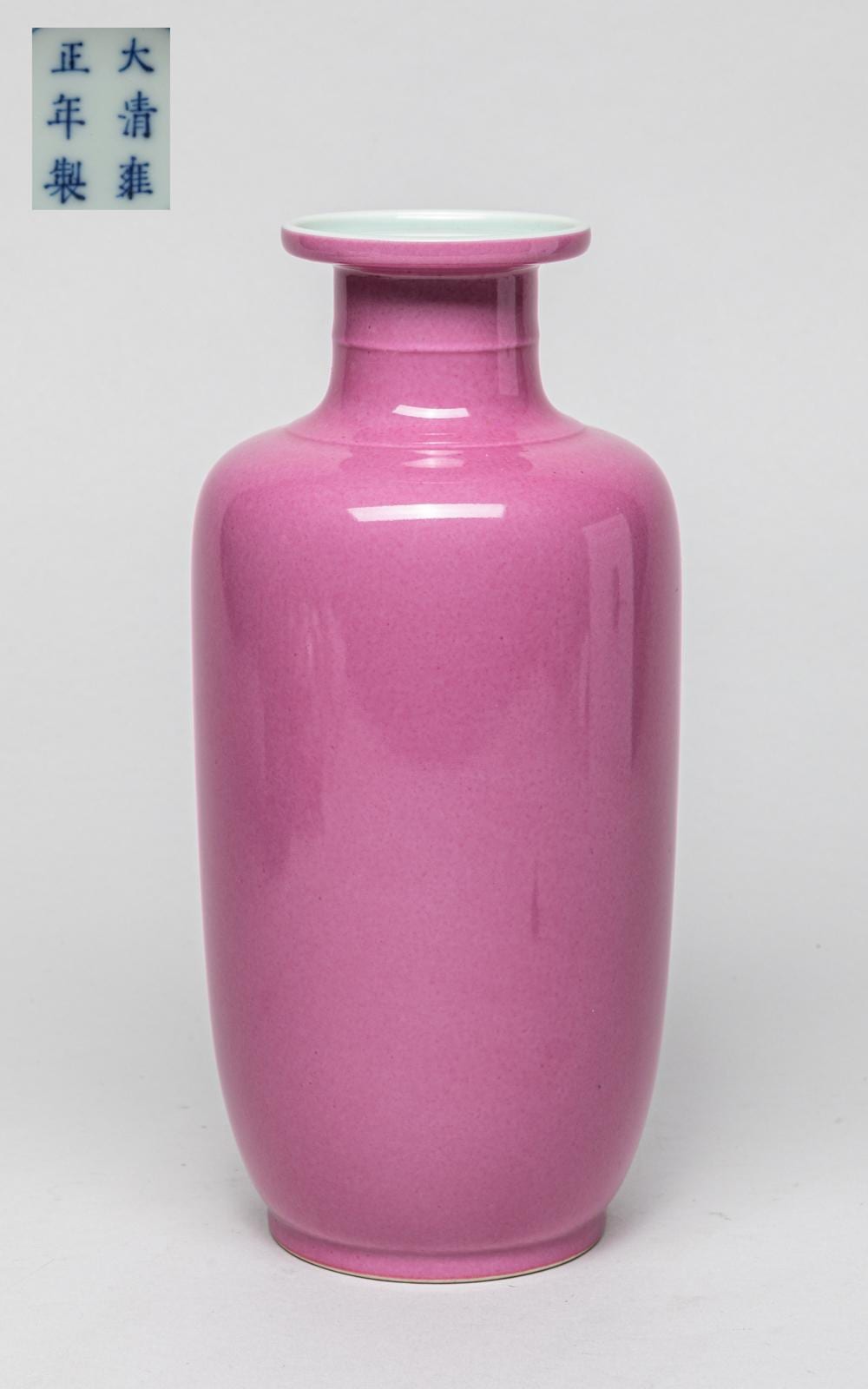 Pink glazed porcelain vase with a wide rounded body and narrow neck on a plain light background.
