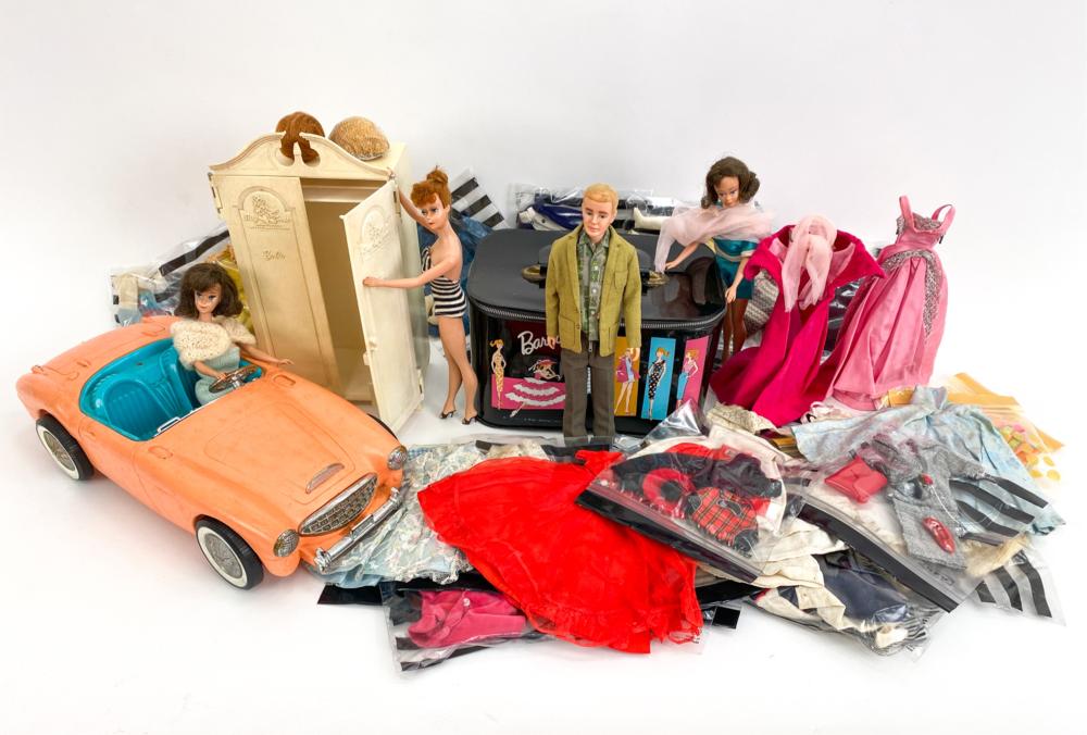 Vintage Barbie-style doll fashion and accessories with multiple dolls, an orange convertible toy car, and boxed clothing on a white background.