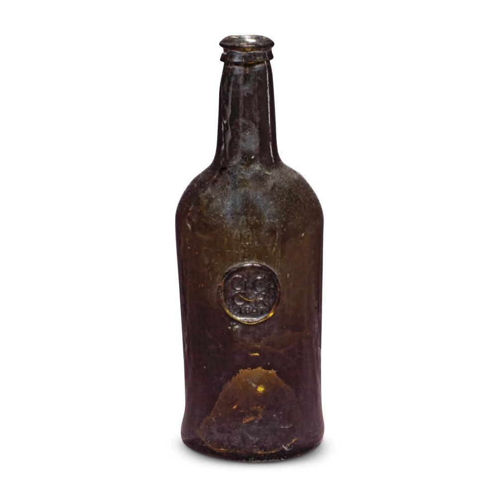 Dark glass wine bottle with a sealed cork and a round label medallion on the front against a white background.