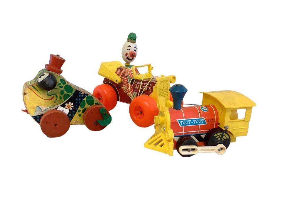 Colorful vintage Fisher-Price-style wind-up clown toy and a yellow farm tractor toy with wheels, shown on a white background.