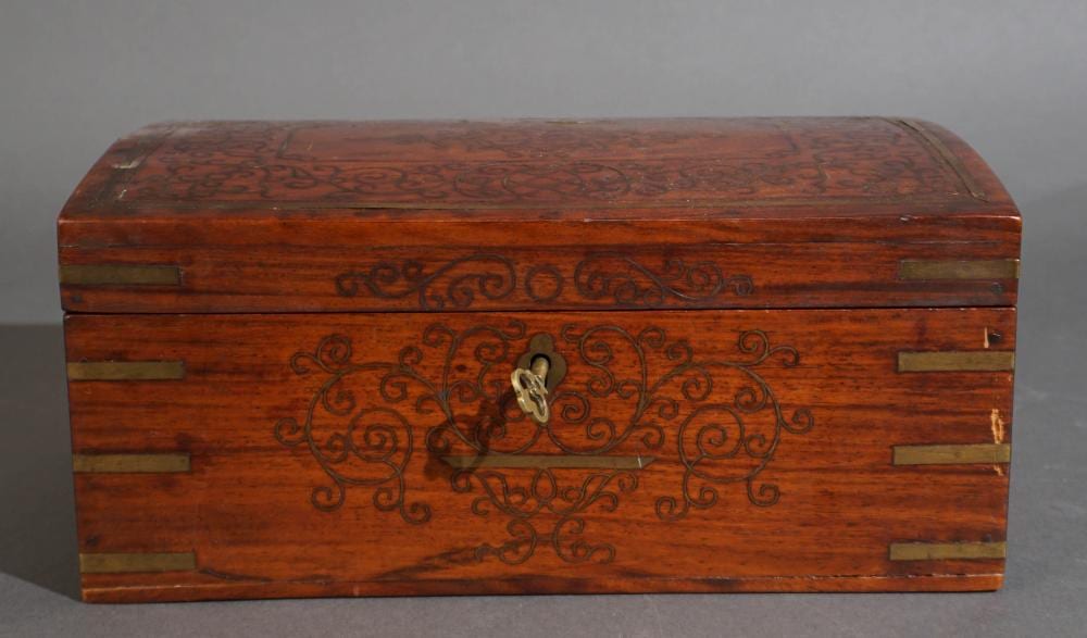 Small wooden jewelry box with two hinged doors and decorative brass-colored inlay panels and scrollwork on the front and lid.
