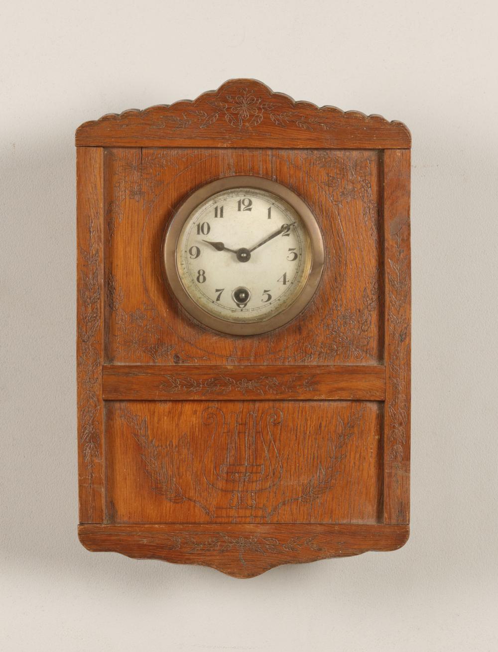 Antique-looking wooden wall clock with an arched case and round white clock face showing the time.