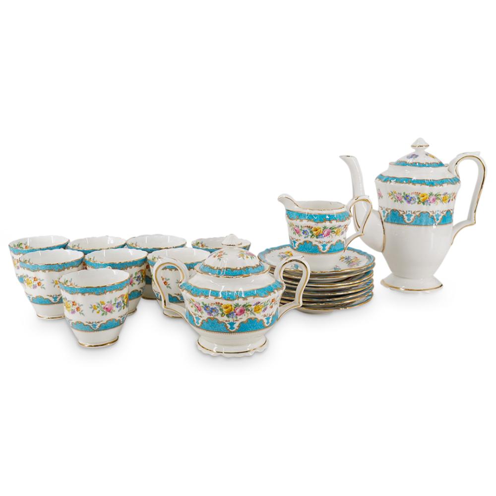 Antique-style porcelain tea set with a teapot, sugar bowl, and multiple cups in white with blue and floral decoration and gold trim.