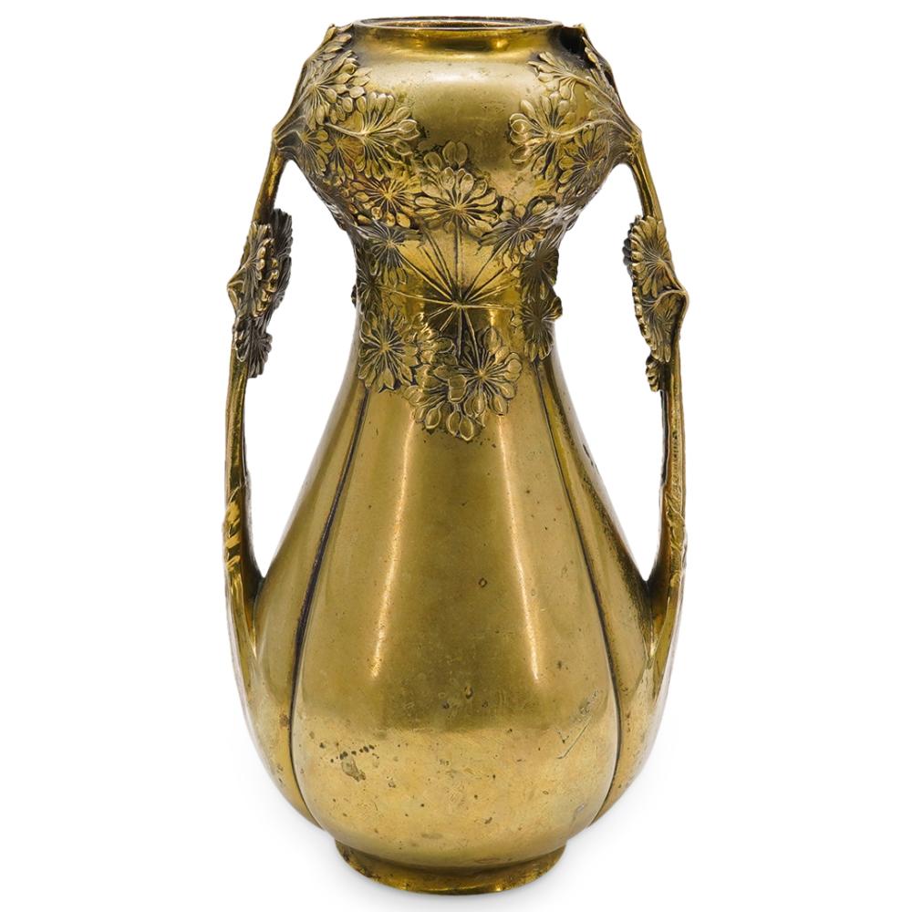 Gold-toned bronze vase with raised floral and leaf designs and two side handles, viewed from the front.