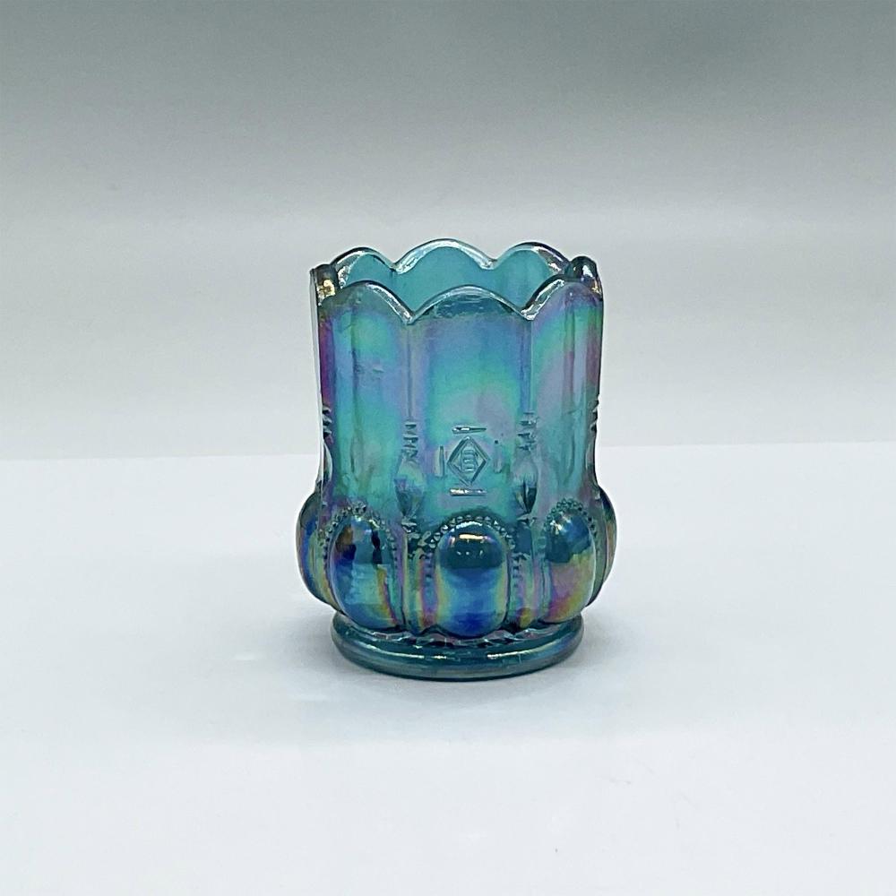 Blue iridescent glass toothpick holder with scalloped rim and embossed panels, photographed on a light background.
