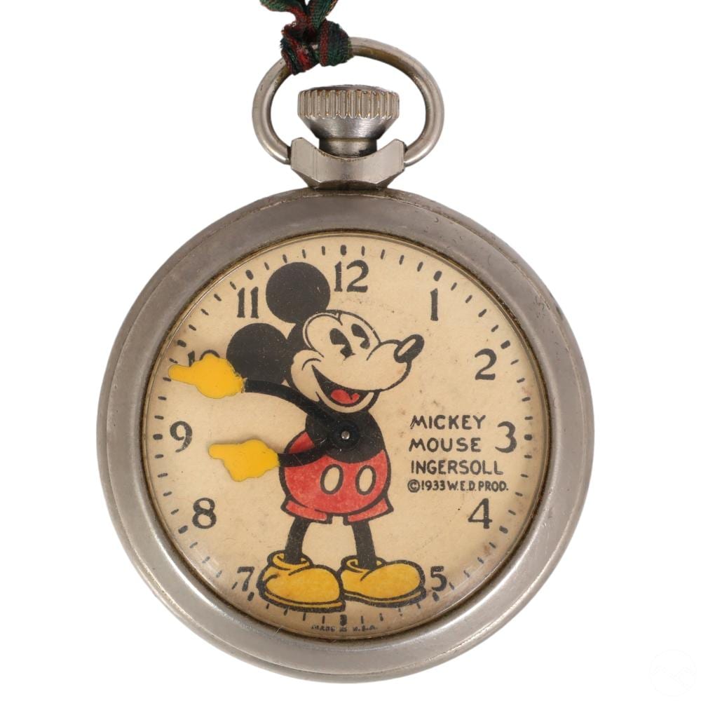 Close-up of a Mickey Mouse pocket watch face with cartoon character and numbers, shown with a metal ring and cloth bow at the top.