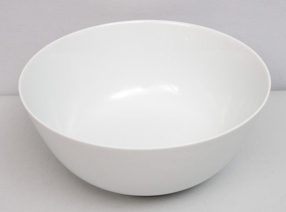White ceramic bowl with a wide rim and shallow interior, photographed against a plain light background.
