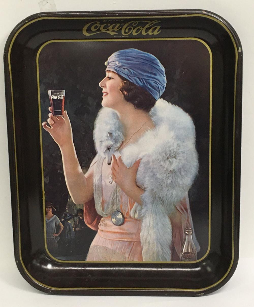 Vintage Coca-Cola tin tray showing a woman in a light fur stole and blue headscarf holding a Coca-Cola bottle.