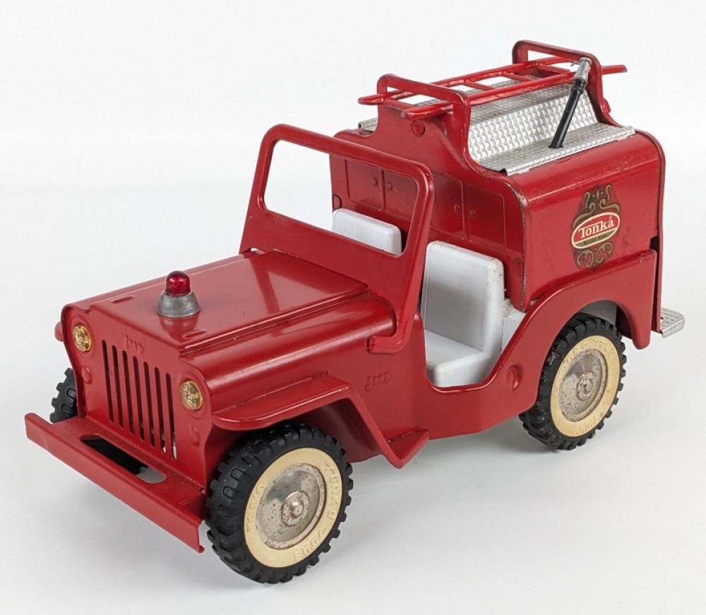 Red toy fire truck with large wheels, open front grille, and raised ladder on top.