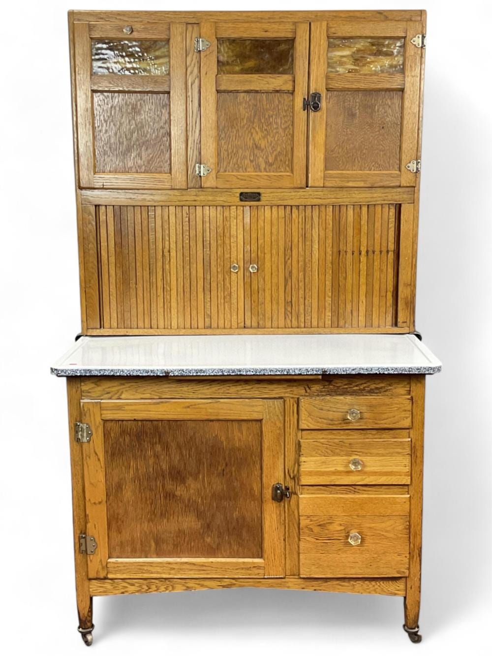 Wooden two-door cabinet with glass panels on top and paneled doors below, with a lower drawer unit and metal hardware.