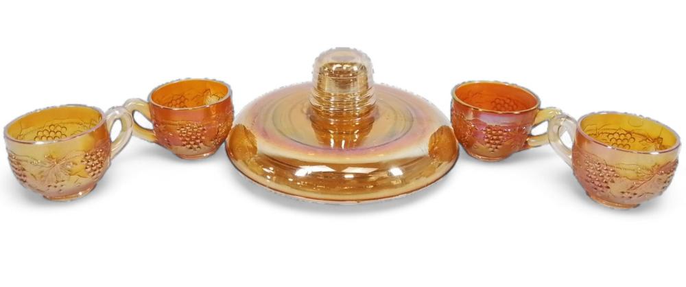 Set of amber carnival glass insulator-style piece with a matching lid and four small cup-like glasses, each with etched bubble pattern.