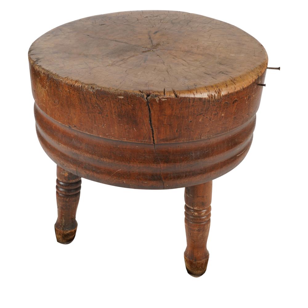 Antique round wooden butcher block table with a circular top and turned legs, shown on a white background.