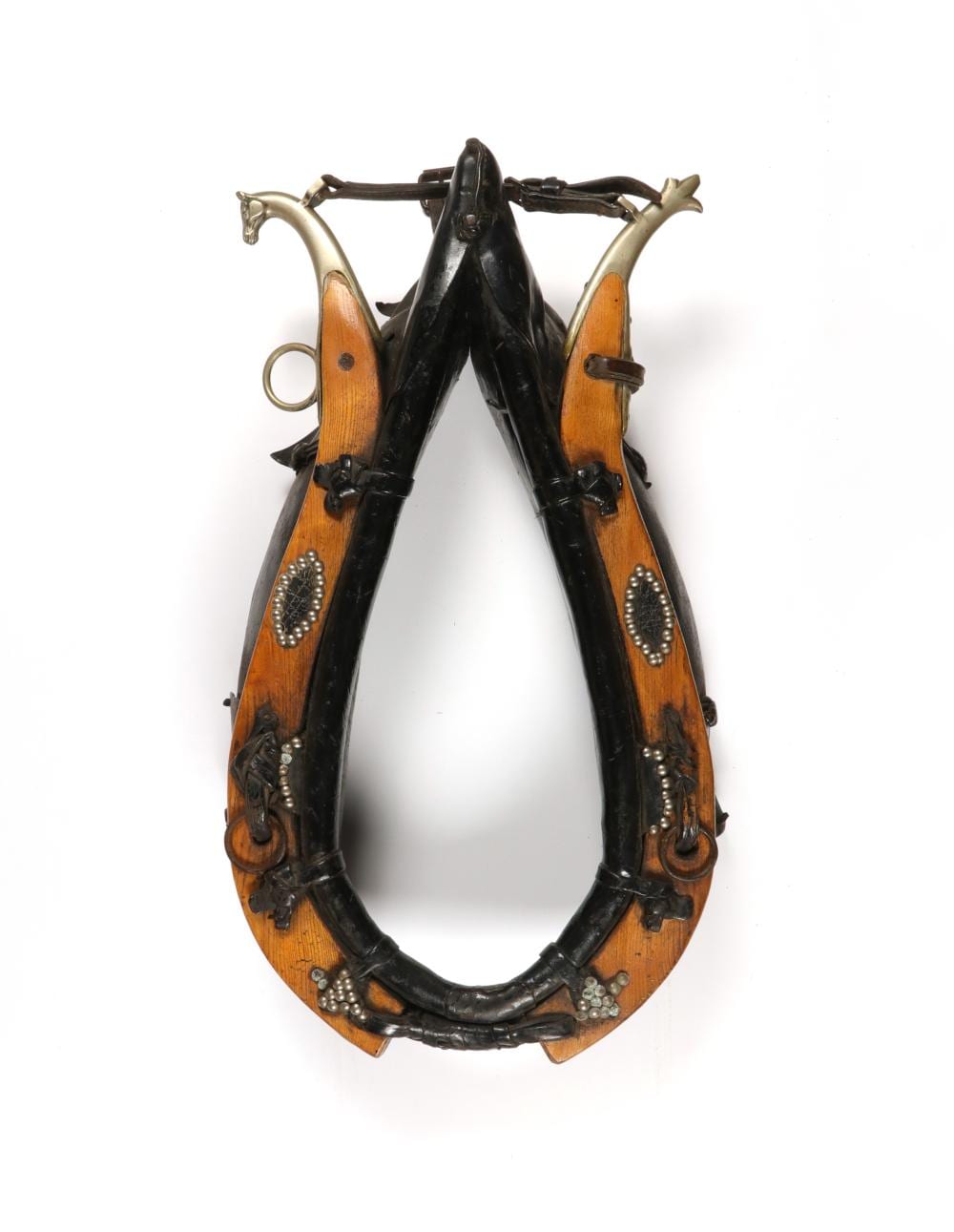 Wood and black leather horse collar harness with metal studs and buckles shown against a white background.