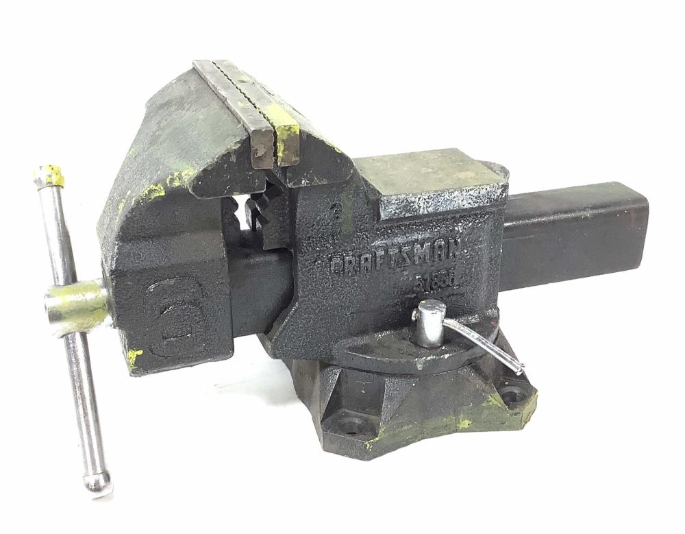 Black metal bench vise with a hinged jaw and a screw handle, shown against a white background.