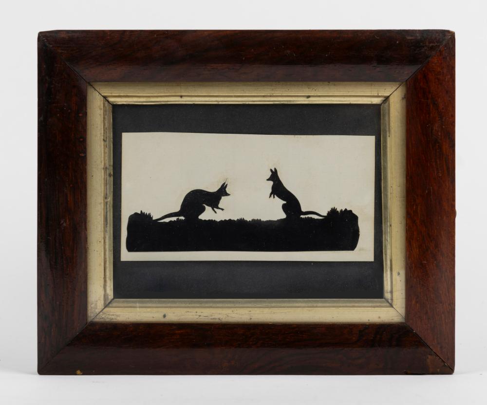 Framed cut-paper silhouette artwork showing two kangaroos on a hill, black against a light background.