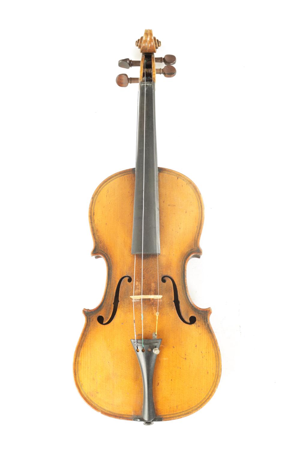Front view of a wooden violin with brown body, chinrest, and scroll at the top against a white background.