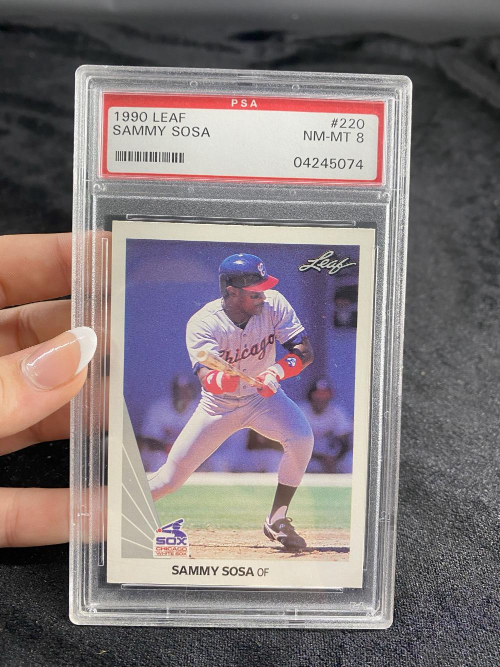 Baseball trading card of Sammy Sosa in a clear PSA slab, showing a batter photo with “Leaf” branding and player name at the bottom.