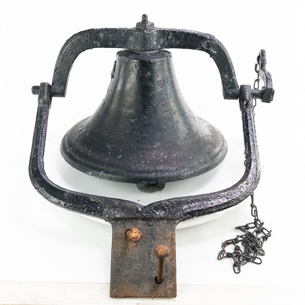 Antique cast iron school bell with clapper, mounted on a metal bracket with a hanging chain