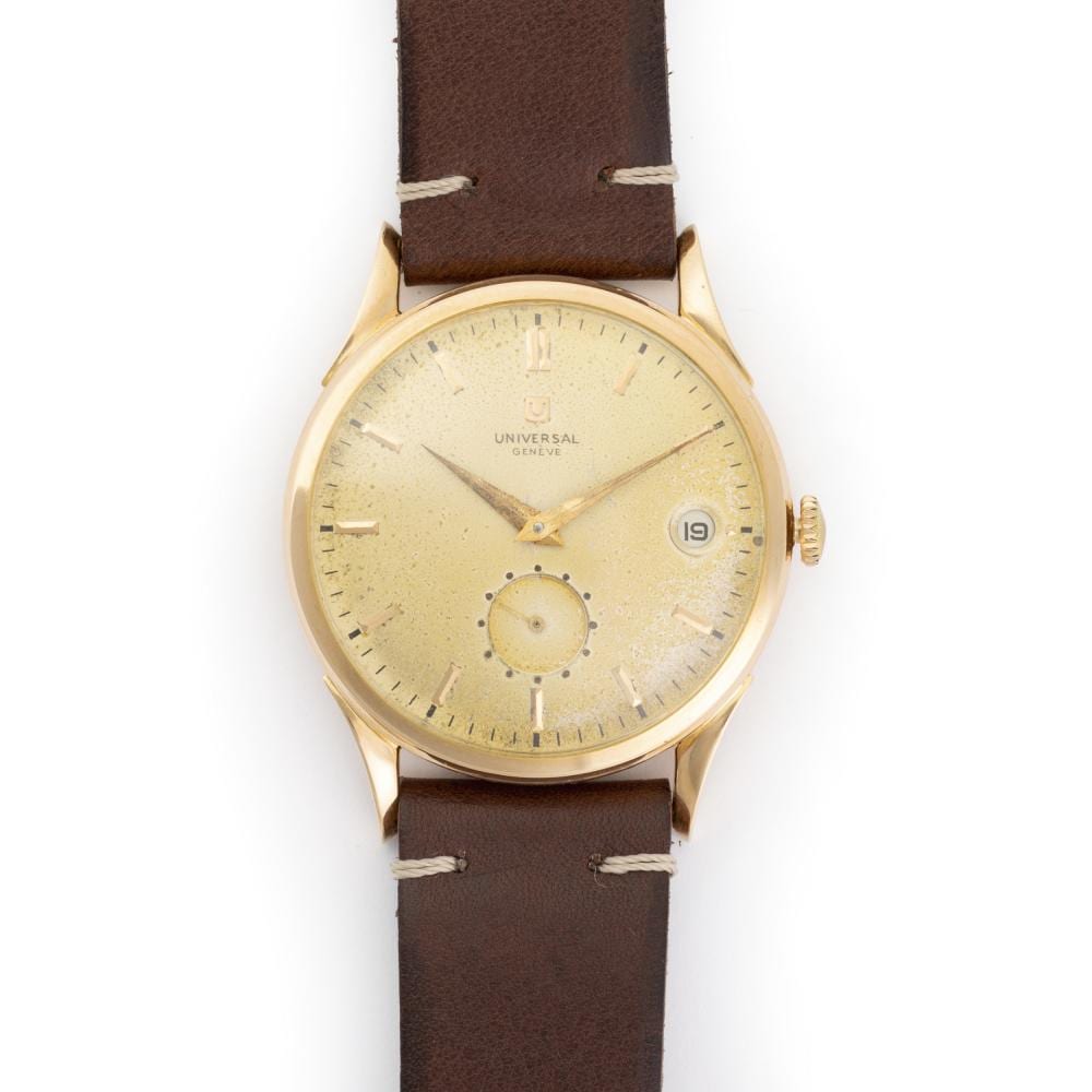 Gold wristwatch with a beige dial, brown leather strap, and date window displaying “19.”