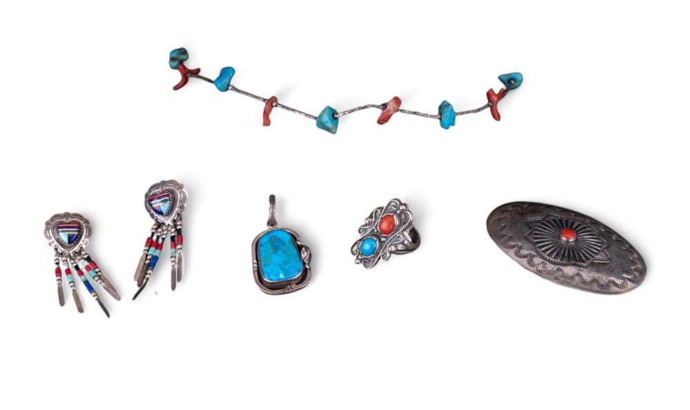 Set of turquoise and coral-colored silver-tone jewelry pieces on a white background, including earrings, a pendant, rings, and a bracelet-like section.