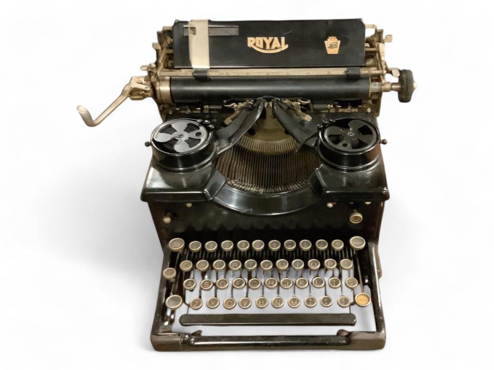 Vintage black and gold Royal typewriter with keys and typebars visible, shown front-on on a white background.