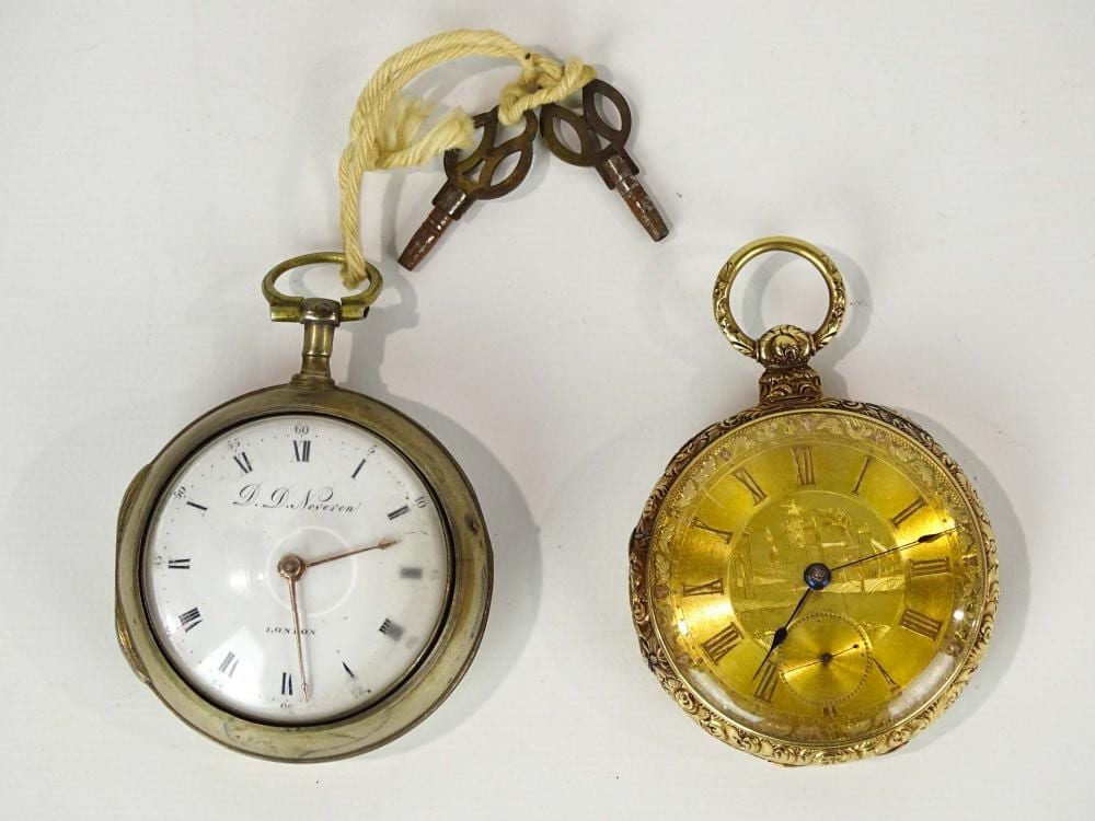 Two vintage pocket watches, one with a white dial showing Roman numerals and hands, and one with a gold-colored dial and Roman numerals.