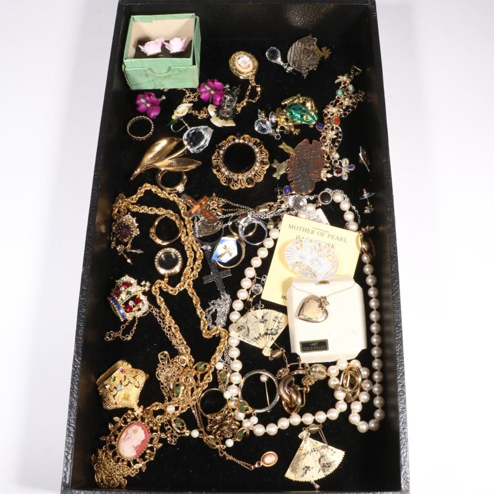 Vintage and contemporary jewelry group with Original by Robert brooch, Swarovski brooch, gold filled jewelry, MOP, rhinestones, rings, lockets, and more. 24"L x 3 1/4"Drop (cameo necklace) sold by Ripley Auctions, lot 420 — auction record photograph