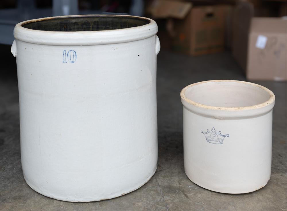 Two white salt-glazed stoneware crocks with rolled rims, one larger and one smaller, with blue markings and a small crown emblem on the smaller crock.