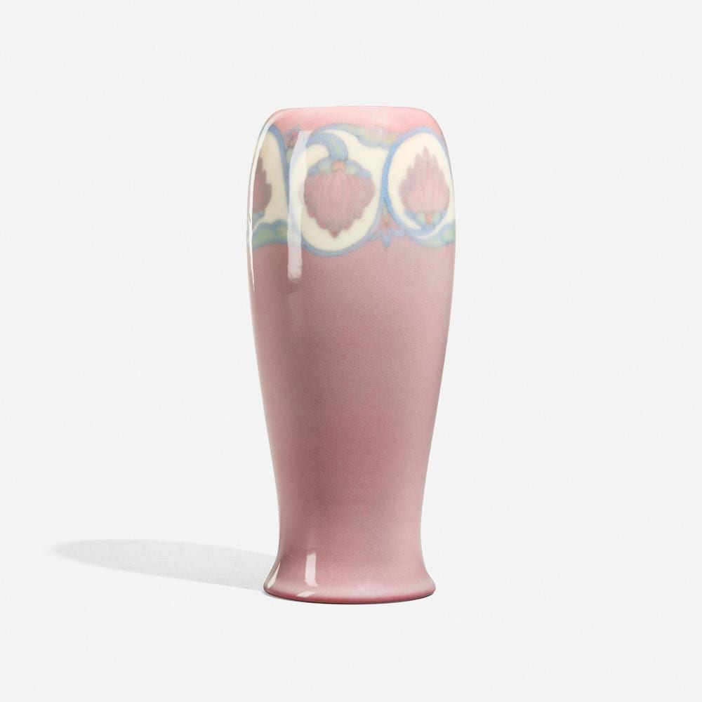 Porcelain vase with a pink finish and blue-and-pink floral medallion decoration near the top.