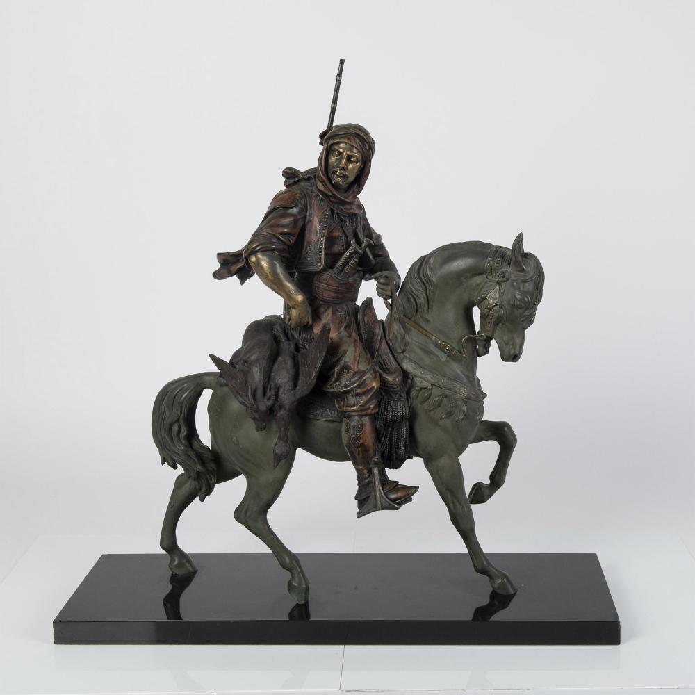 Bronze-toned painted metal sculpture of a mounted soldier with a long spear, seated on a rearing horse on a dark base.