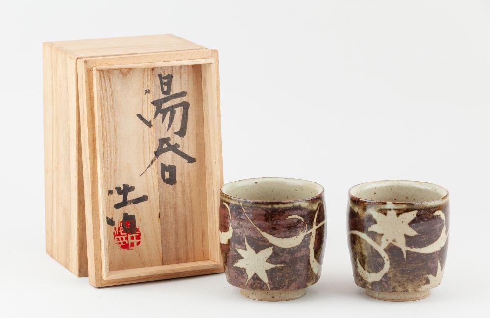 Hiroshi Murata comparable auction result: hiroshi murata born 1943 a meoto pair of yunomi covered in iron glaze with wax resist decoration impressed marks tallest 8 5cm with signed box 2