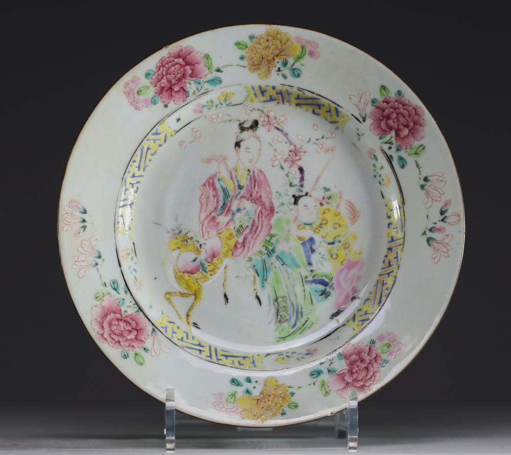 Porcelain decorative plate with a central painted figure and flowers, bordered by colorful pattern and gold accents.